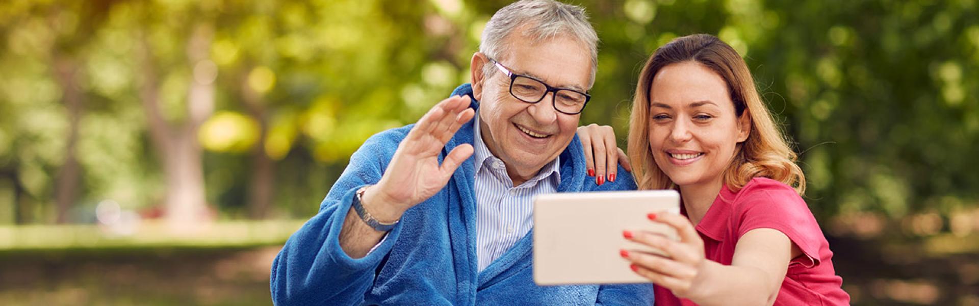 Woman and Elderly man looking at tablet