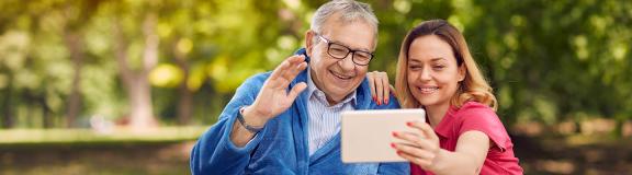 Woman and Elderly man looking at tablet